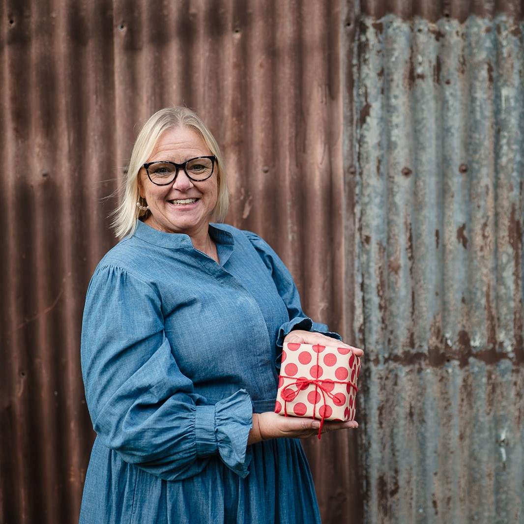 Jane holding gift wrapped present for Brits in Australia