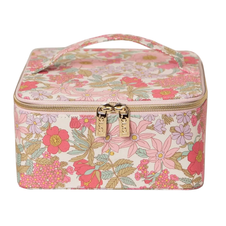 A square vanity case with a floral print in pink, red, and green on a cream background, featuring a top handle and gold-tone zippers.