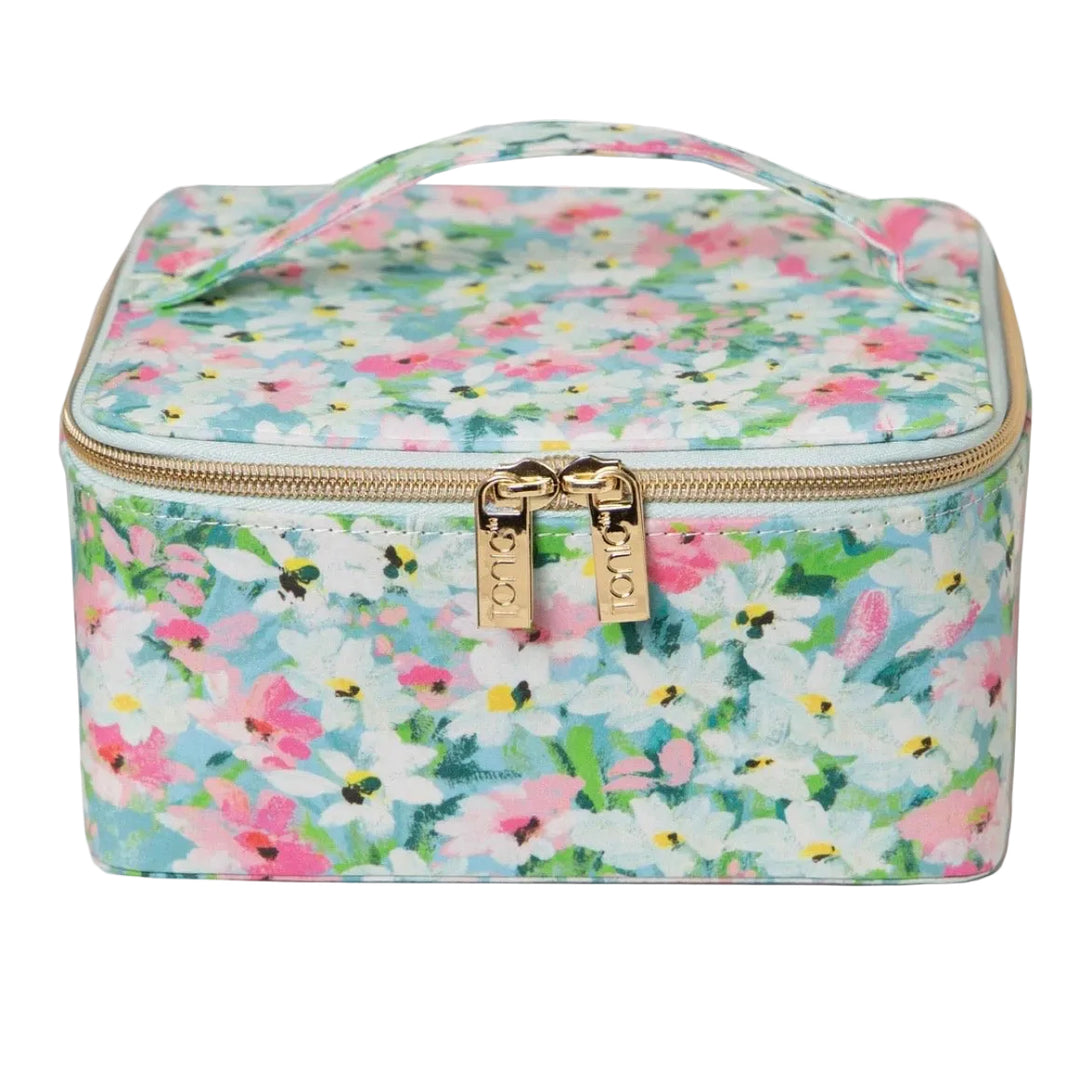 A square vanity case with a floral print featuring pink, white, and green flowers on a light blue background, with gold-tone hardware and a top handle.