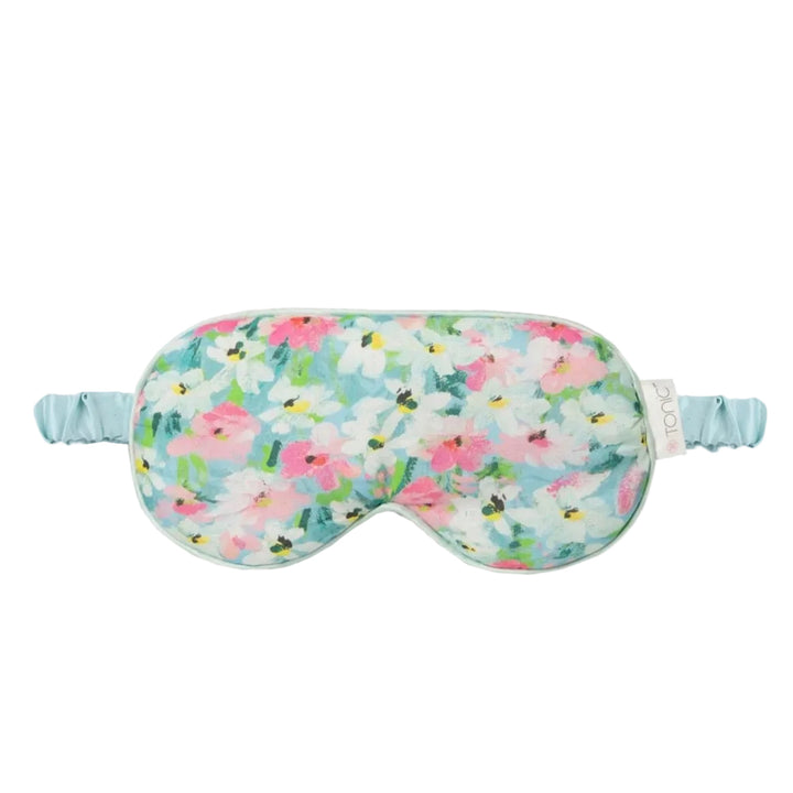 A floral sleep mask with a light blue elastic strap, featuring a pattern of pink, white, and green flowers on a light blue background.