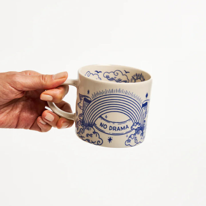 Hand holding a mug with &
