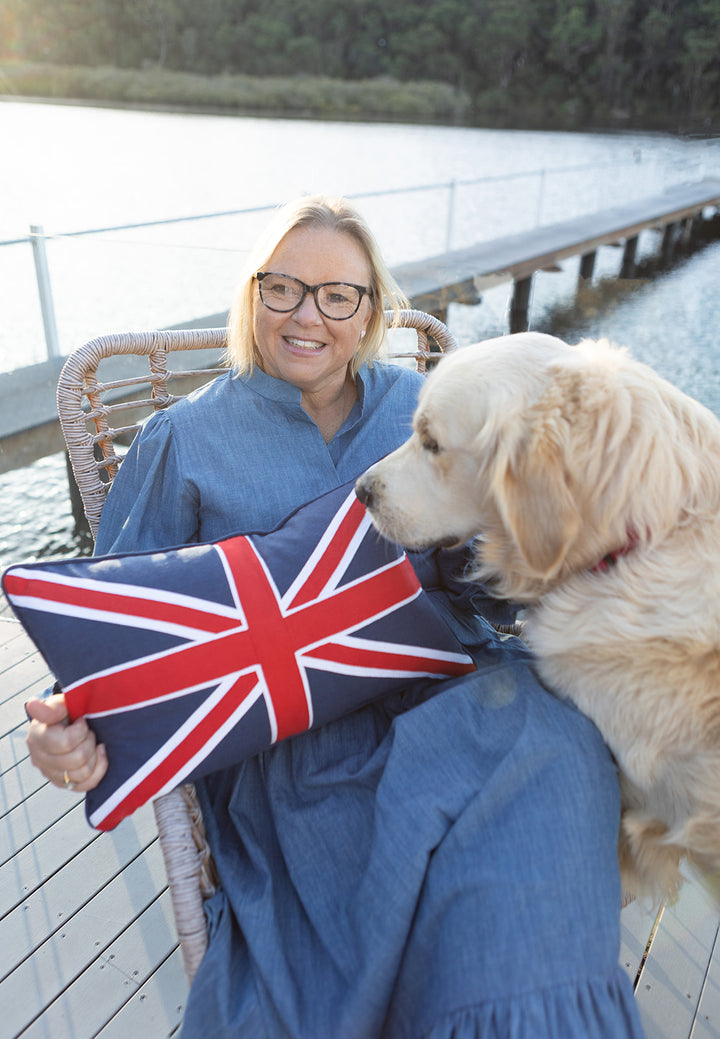 Jane Fonti from Rubys Home Store holding Union Jack cushion with Toby