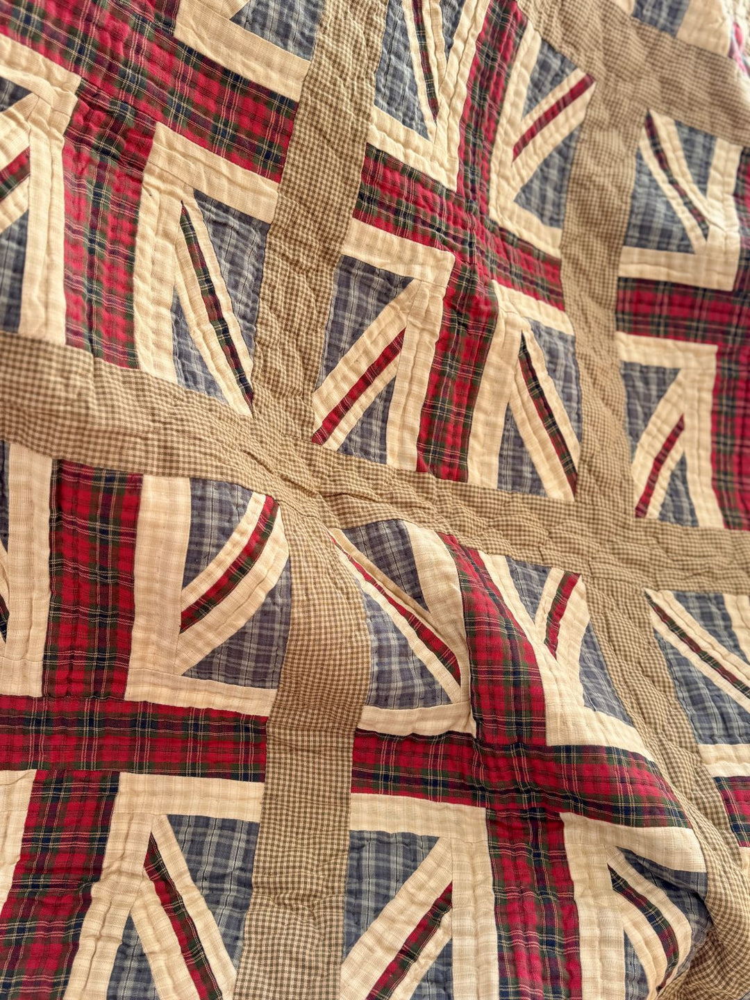 Quilt with Union Jack pattern featuring red, blue, and beige colors.