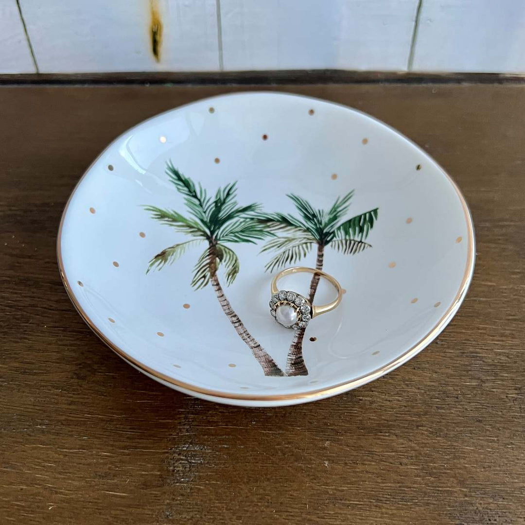 white tropical palm trinket dish with gold polka dots with ring, top view