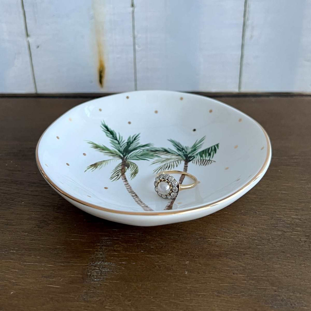 white tropical palm trinket dish with gold polka dots with ring, side view